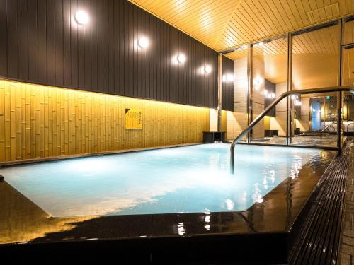 a large swimming pool in a building with lights on it at APA Hotel & Resort Osaka Namba Ekimae Tower in Osaka