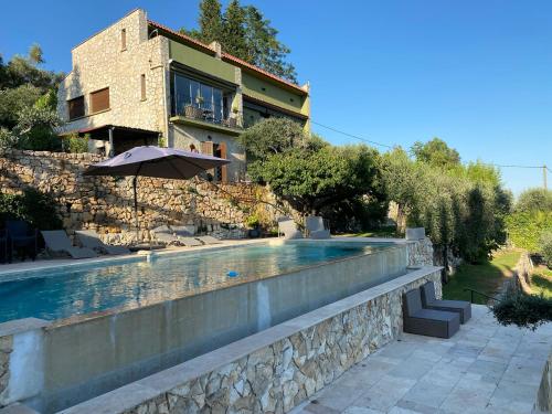 ein Haus mit einem Swimmingpool vor einem Gebäude in der Unterkunft Dieu L'Amour - Molinard in Châteauneuf
