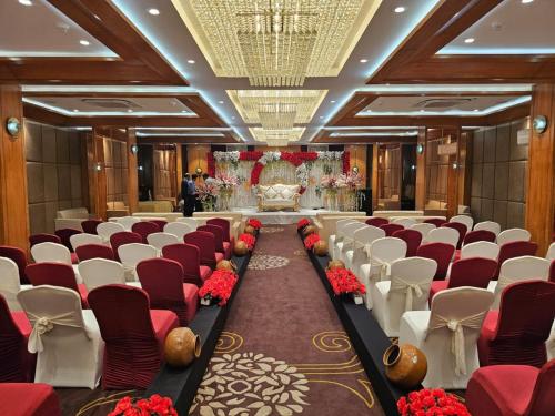 a banquet hall with red and white chairs and a altar at Hotel Alwar Royals in Alwar