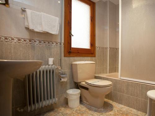 a bathroom with a toilet and a sink and a tub at Hostal Aragon in Ejea de los Caballeros