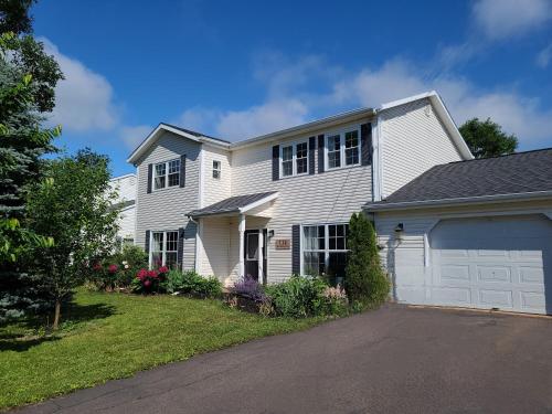 a white house with a garage at Yuan's Cozy 4BR House in Charlottetown in Cornwall
