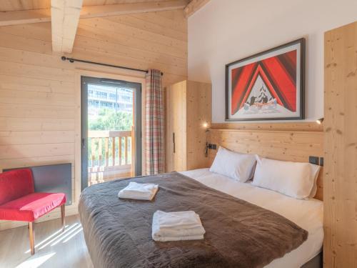 ein Schlafzimmer mit einem großen Bett und einem roten Stuhl in der Unterkunft Luxueux Duplex 127m² aux Pistes - Parking Inclus - FR-1-645-86 in Huez