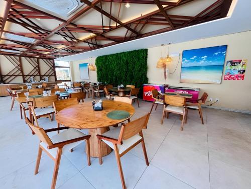 ein Esszimmer mit Holztischen und Stühlen in der Unterkunft Flat Makia Beach Experience Muro Alto Porto de Galinhas in Porto De Galinhas