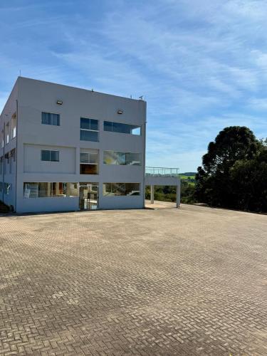 ein großes weißes Gebäude mit vielen Fenstern in der Unterkunft Chácara Cidade da Divina Misericórdia in Araucária