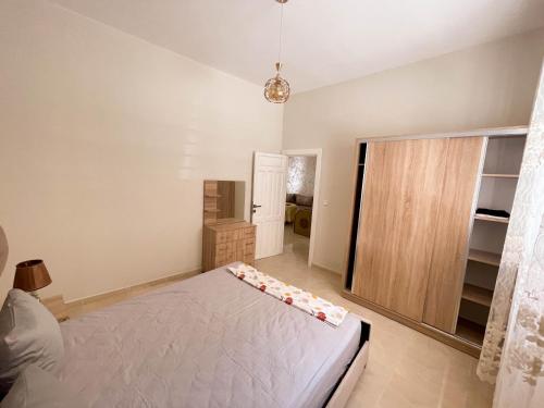 a bedroom with a white bed and a closet at Appartement in ground floor in Al houceima in Al Hoceïma