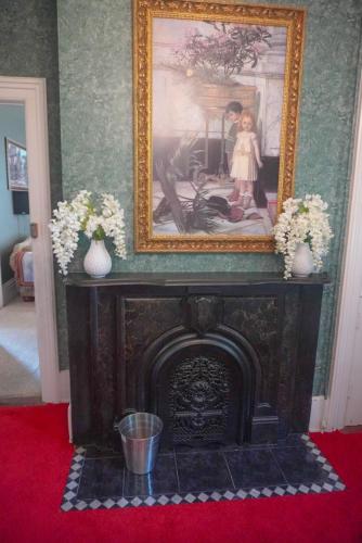 a fireplace in a living room with a picture above it at Main Oak Manor in Gallipolis