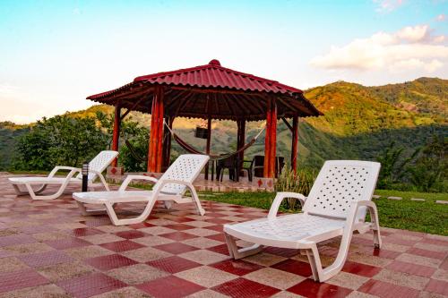 a group of white chairs and a gazebo at Quinta Maka VistaHermosa in Villeta