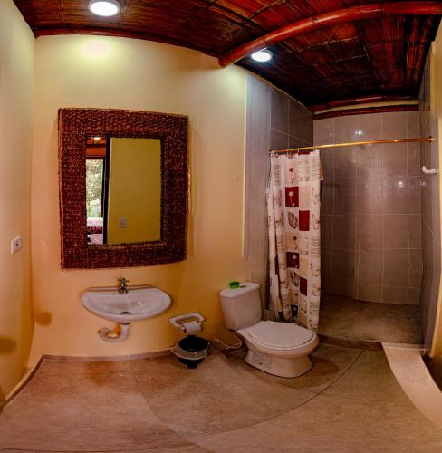 a bathroom with a toilet and a sink and a mirror at Quinta Maka VistaHermosa in Villeta