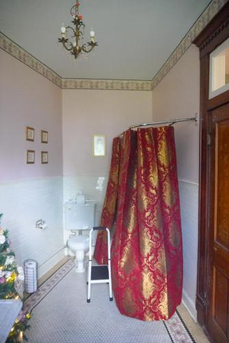 a bathroom with a red shower curtain and a toilet at Main Oak Manor in Gallipolis