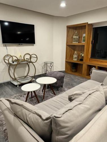 a living room with a couch and tables and a tv at Zona Rosa Amberes 33 a 2 cuadras del CAS y del Ángel in Mexico City