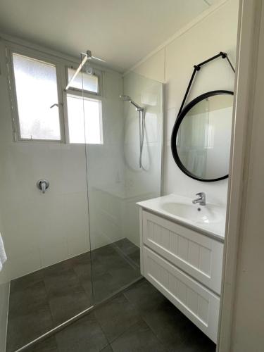 un bagno bianco con lavandino e specchio di Bestbrook Mountain Farmstay a Maryvale