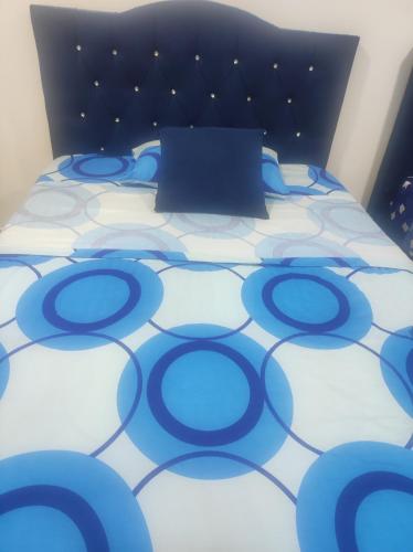 a blue and white bed with a black head board at Apartamento campestre guaduales en el estadio in Santa Rosa de Cabal