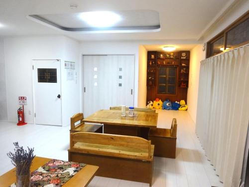 a living room with a table and a dining room at Guest House OHANA in Kami-furano