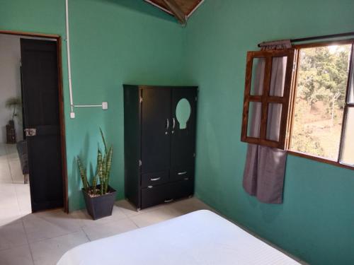 a bedroom with a bed and a green wall at Casa Campestre en Guarne in Guarne