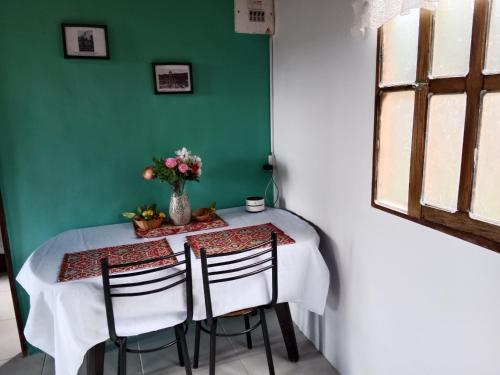 a table with two chairs and a vase with flowers at Casa Campestre en Guarne in Guarne