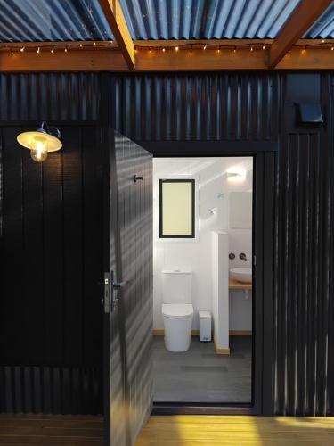 a bathroom with a toilet inside of a building at Haven Cabin - No road access - just a boat ride away in Endeavour Inlet