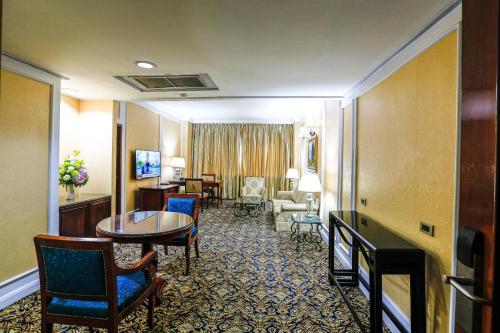 a hotel room with a table and chairs at Kosa Hotel & Wellness Center in Khon Kaen