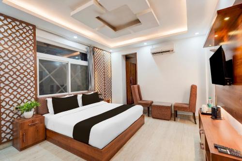 デヘラードゥーンにあるSuper Townhouse Rispana Pul Haridwar Road Dehradunのベッドとテレビのある寝室