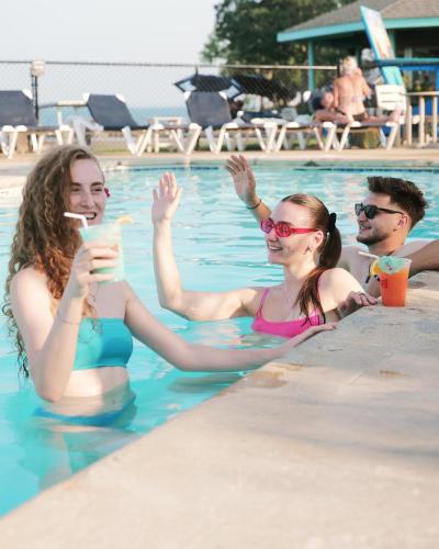 two women sitting in a swimming pool with drinks at Bayshore Resort At Put-In-Bay in Put-in-Bay