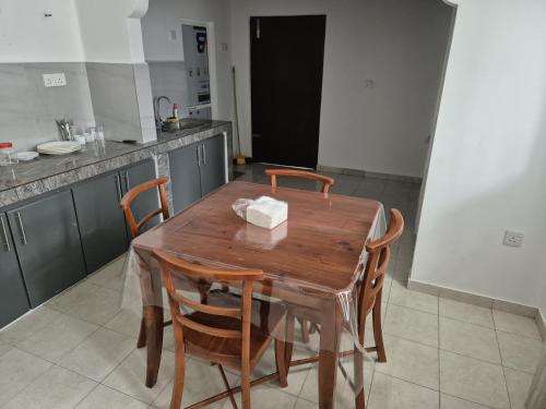 a wooden table with four chairs in a kitchen at Comfortable Stay in Colombo in Rajagiriya