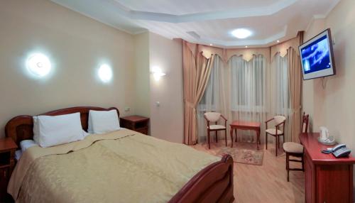 a hotel room with a bed and a television at Red Stone in Truskavets