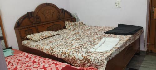 a bedroom with a bed with a wooden headboard at Sanjay HomeStay in Gwalior