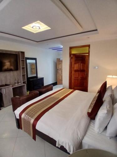 a bedroom with a large bed and a living room at Esiankiki Resort & Spa - Nanyuki in Nanyuki