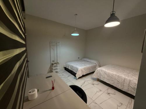 a room with two beds and a table in it at Villa los Encinos 