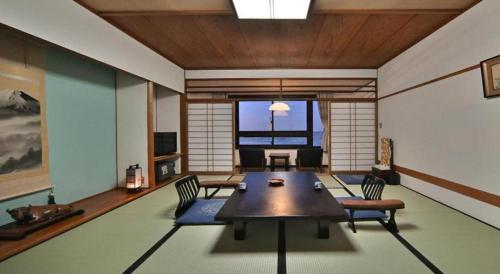 a living room with a table and chairs in a room at Futami Onsen Hotel Seikai in Ise