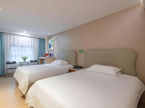 a hotel room with two beds and a room with at Leisurely Hotel Shenzhen in Shenzhen