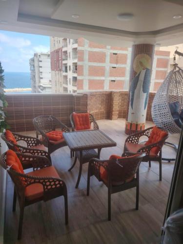 a balcony with a table and chairs and a view of the ocean at Apartment with panoramic sea view sidi bshr Families only in Alexandria
