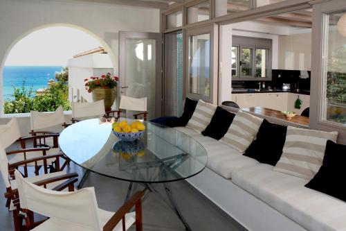 a living room with a white couch and a glass table at La Belle Helene in Kymi