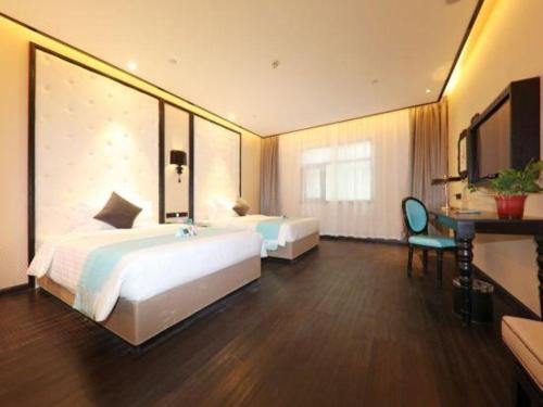 a hotel room with two beds and a desk at Xana Hotelle·Tianshui Shangyi Plaza in Tianshui