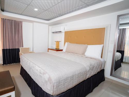 a bedroom with a large bed in a room at Muna Hotel in San Pedro Sula