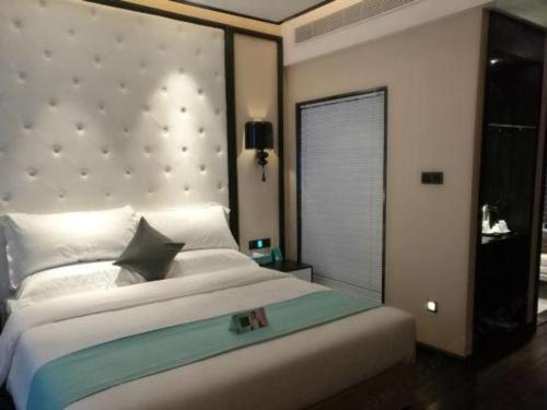 a bedroom with a large bed and a window at Xana Hotelle·Tianshui Shangyi Plaza in Tianshui