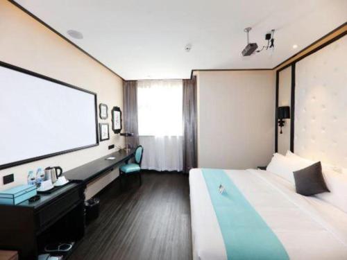 a hotel room with a large bed and a projection screen at Xana Hotelle·Tianshui Shangyi Plaza in Tianshui