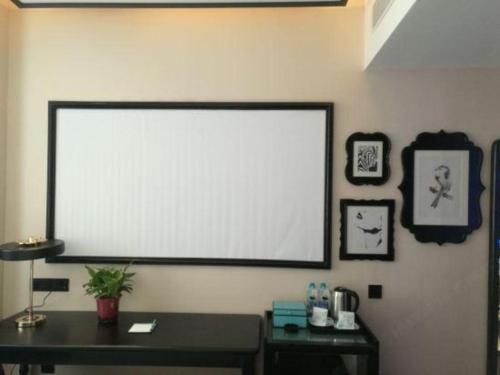 a projection screen on a wall in a room at Xana Hotelle·Tianshui Shangyi Plaza in Tianshui