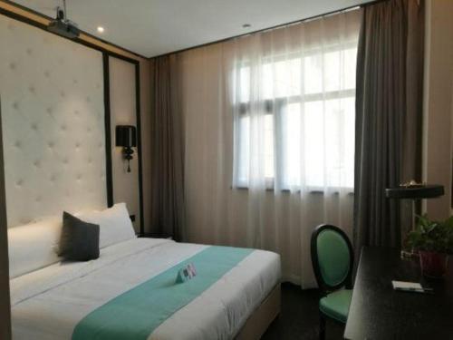 a hotel room with a bed and a window at Xana Hotelle·Tianshui Shangyi Plaza in Tianshui