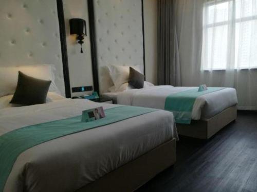 a hotel room with two beds and a window at Xana Hotelle·Tianshui Shangyi Plaza in Tianshui