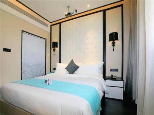 a bedroom with a large bed and a large window at Xana Hotelle·Tianshui Shangyi Plaza in Tianshui