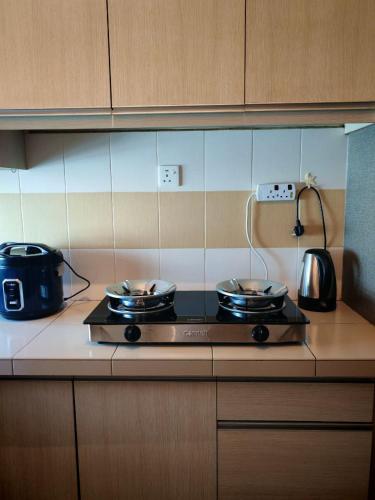 a kitchen with a stove with pots and pans on it at Homestay Sakinah No 39 in Tanjung Malim