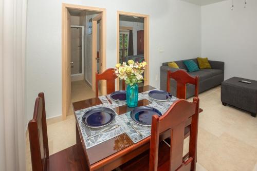 a dining room table with blue plates and flowers on it at Alpha's Place - Unit 2D in Sandy Bay