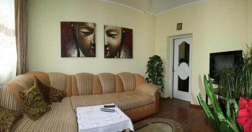 a living room with a couch and two paintings on the wall at Sadiba Pri Dorogi in Kosiv