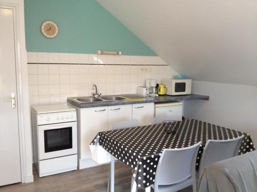 une petite cuisine avec une table et un évier dans l'établissement Domaine Des Mille Oiseaux, à Villiers-Charlemagne