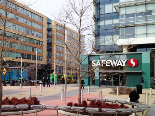 a city street with buildings and a courtyard with a sign for swapeway at River View Suite - The Wharf DC by Monthier in Washington