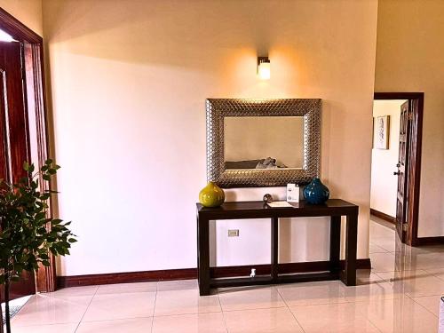 a room with a table with a mirror on the wall at Casa Pors Luxury Apartment with Security, Pool, & Gym in Liguanea