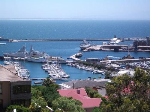 a harbor with boats and ships in the water at A Boat House in Simonʼs Town