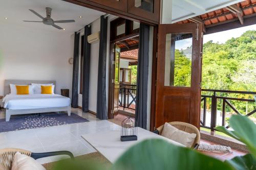 a bedroom with a bed and a balcony at Villa 6 - Private Pool WOW Holiday Homes in Pantai Cenang