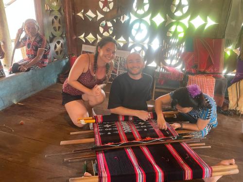 a man and a woman standing next to a table of ties at Vuglamping in Hue