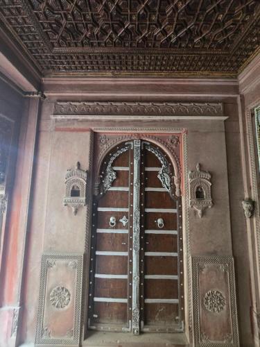 an ornate door in a room with a ceiling at The Prince Haveli in Bikaner
